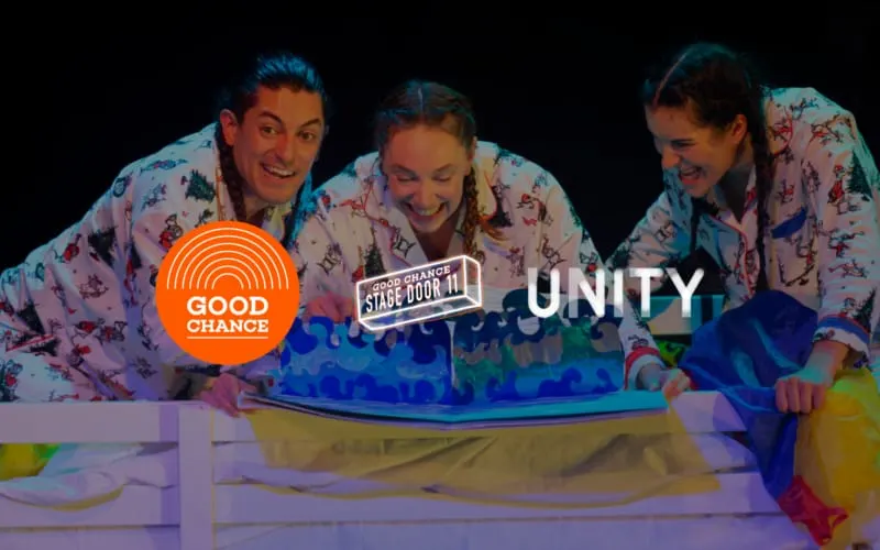 Three people in matching floral shirts interact with a glowing blue interactive display on stage.