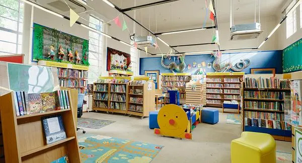 Children's library area with bookshelves, colourful seating, educational displays and play equipment.