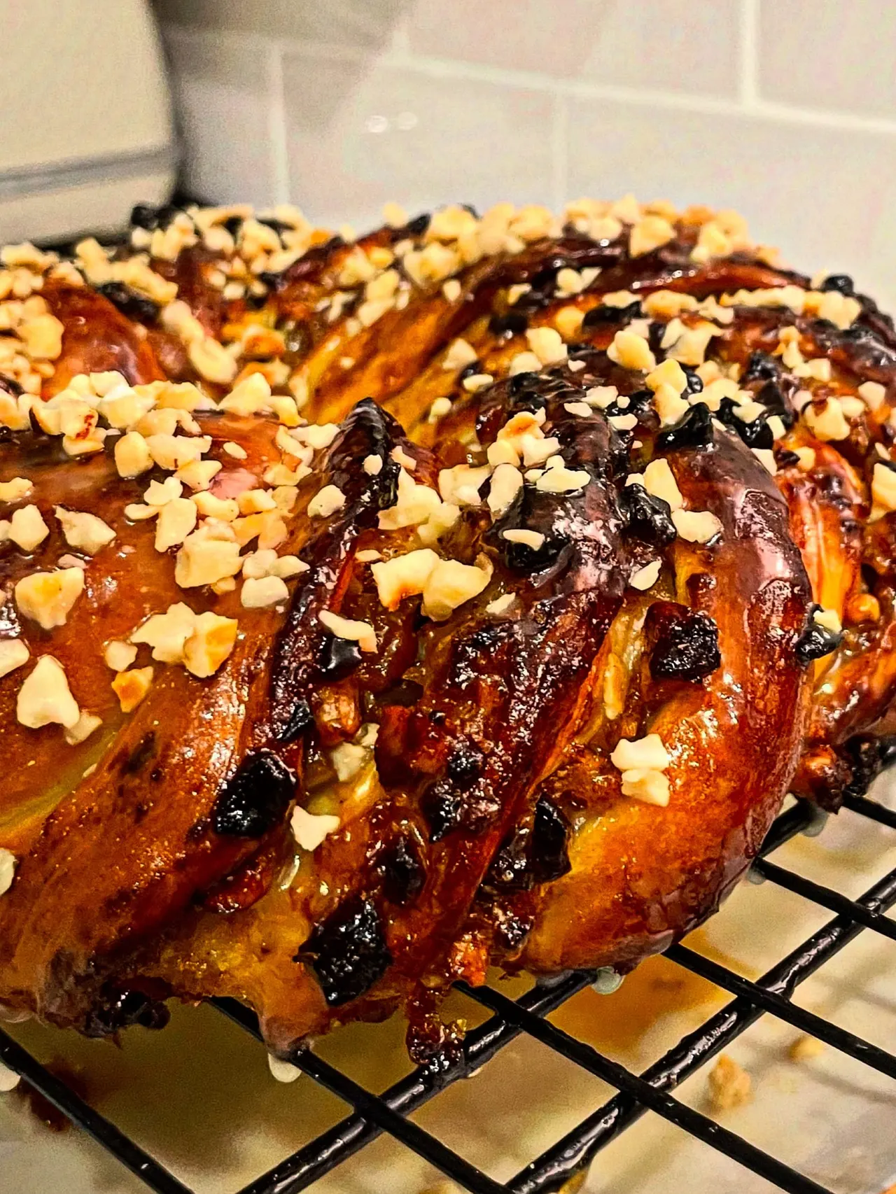 Freshly baked pastries with chocolate glaze and flaked almond topping cooling on a wire rack.
