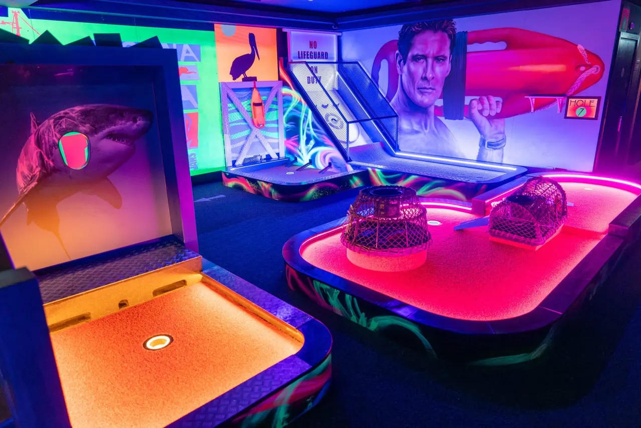 Colourful indoor mini golf course with neon-lit themed holes, glowing walls, and vibrant interactive displays.