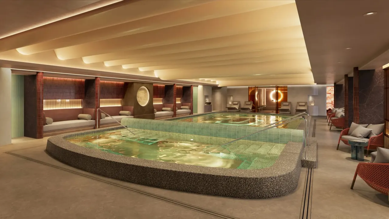 Indoor spa with hot tubs and swimming pool, seating areas with cushions along the sides.