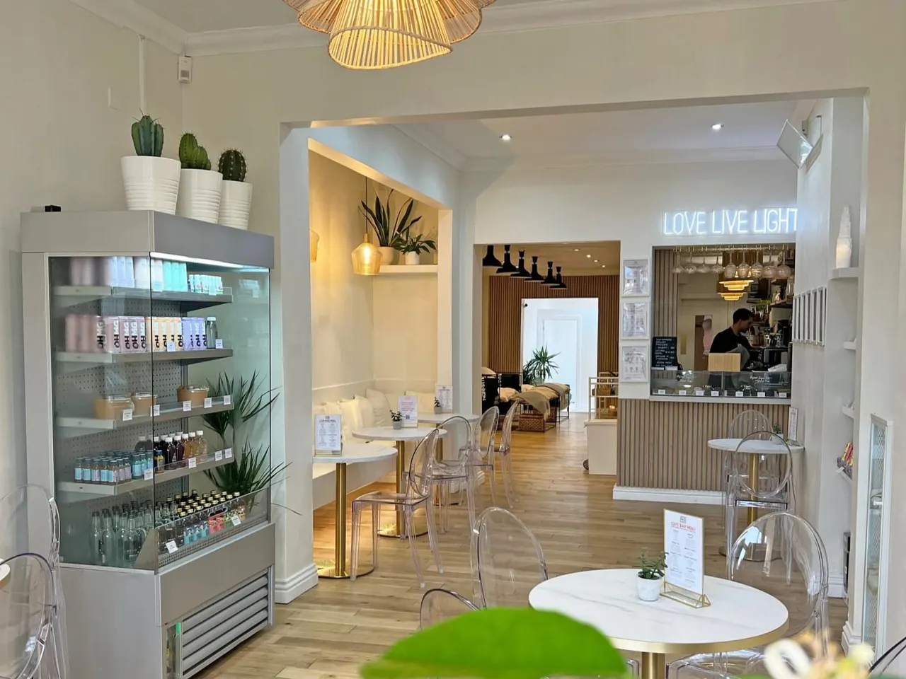 Modern wellness spa interior with seating area, service counter, display shelving, and neon signage.