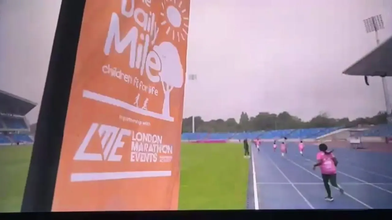 Children running on an athletic track at a sports stadium during a marathon event.