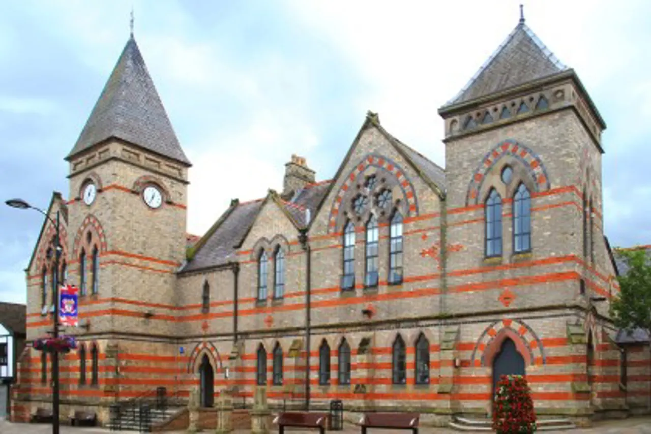 Victorian Gothic-style red brick and stone building with twin spires and arched windows, the Holywood Library.