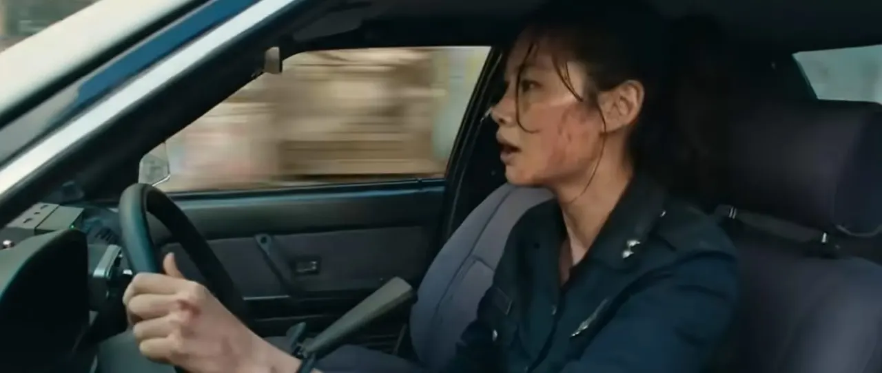 Person driving a car, gripping the steering wheel with an intense expression.