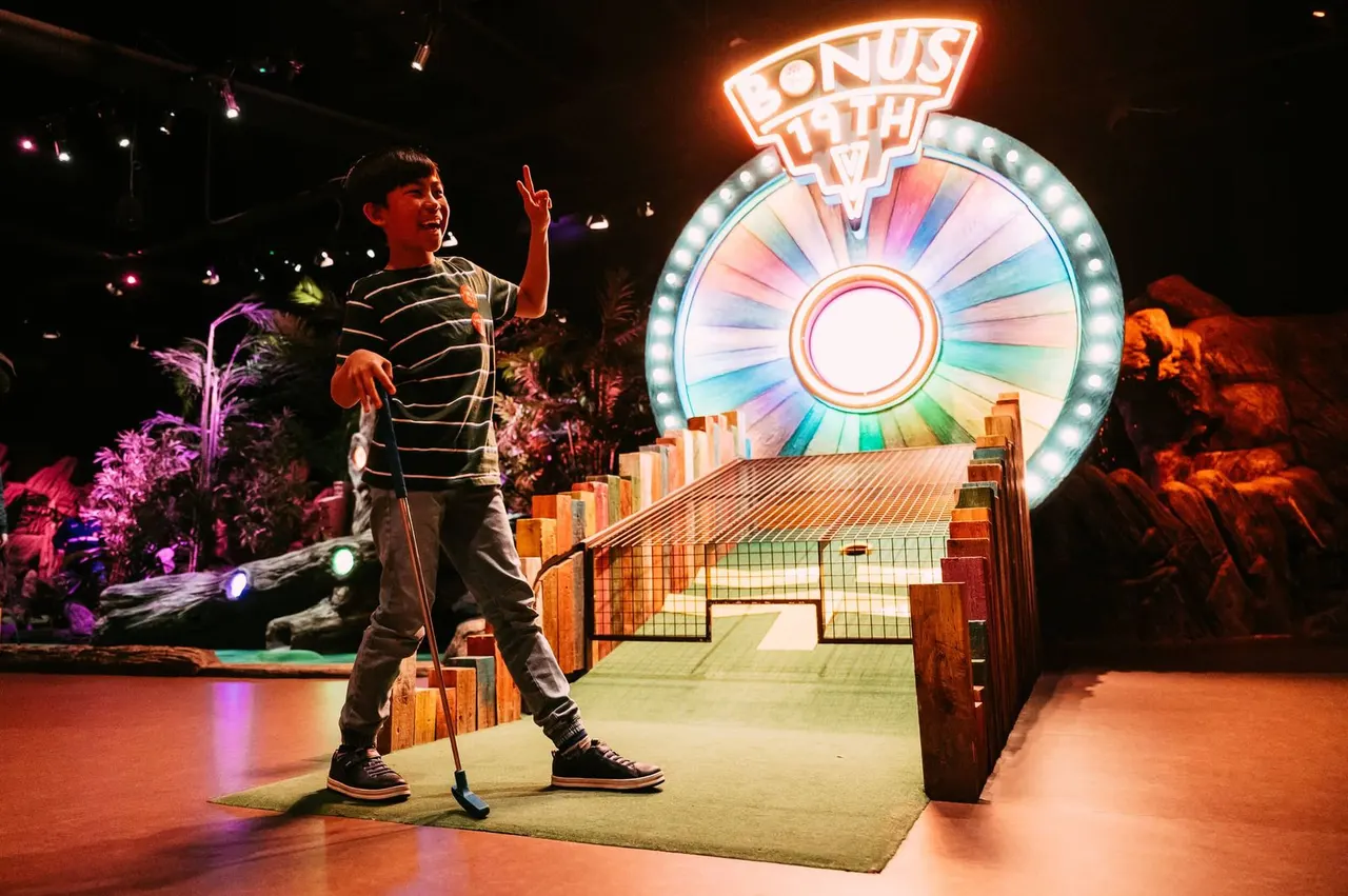 Guests playing indoor adventure golf at Treetop
